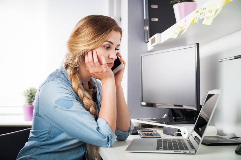 Stressed woman talking on phone at home office, business problems concept