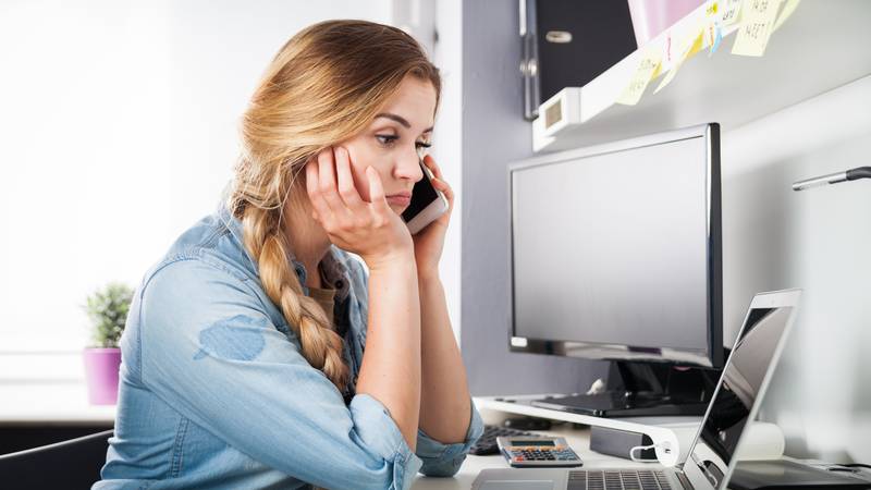 Stressed woman talking on phone at home office, business problems concept